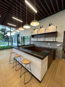 a kitchen with two stools and a counter with some lights at Mid Valley Luxury 6pax Resort谷中城奢华风格套房 in Kuala Lumpur