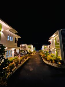 uma vista nocturna de uma entrada entre duas casas em Luxe Hotel - Rooms & Villas Wayanad em Wayanad