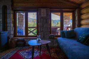 uma sala de estar com um sofá, uma mesa e janelas em Vucje Brdo in Kolasin em Kolašin