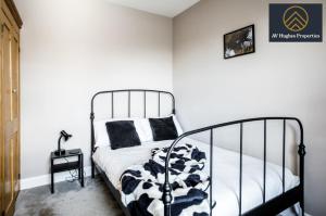 a bedroom with a black and white bed and a table at Spacious Victorian House By AV Hughes Properties - Business & Families with Fast Wi-Fi and Free Parking in Northampton