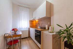 uma pequena cozinha com um lavatório e uma mesa em Flexible SelfCheckIns 57 - Zagreb - Parking - New em Zagreb