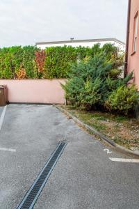 a parking lot next to a wall with bushes at Flexible SelfCheckIns 57 - Zagreb - Parking - New in Zagreb