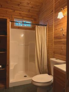 y baño con aseo blanco y ducha. en neversink river resort, 