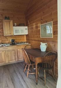una cocina con mesa y sillas en una cabaña en neversink river resort, 