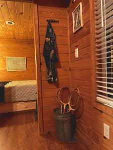 Cette chambre est dotée de murs en bois et d'un seau de raquettes. dans l'établissement neversink river resort, 