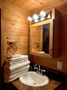 y baño con lavabo, espejo y toallas. en neversink river resort, 