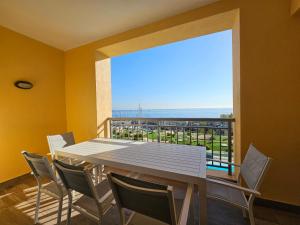 una sala da pranzo con tavolo, sedie e una grande finestra di Stunning Seafront Portomaso Apartment a Paceville