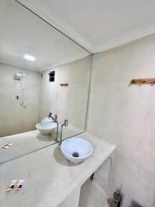 a white bathroom with a sink and a mirror at Pousada VIGLAMO JERI in Jericoacoara