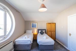 Duas camas num quarto com uma janela em Riverside Townhouse Carrick em Carrick on Shannon