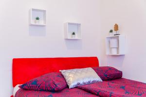 um sofá vermelho com duas almofadas num quarto em Flexible SelfCheckIns 57 - Zagreb - Parking - New em Zagreb