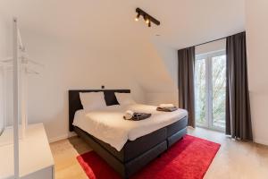 a bedroom with a large bed with a red rug at Modern & Spacious House in Kortrijk