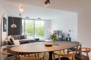 a living room with a table and chairs at Modern & Spacious House in Kortrijk