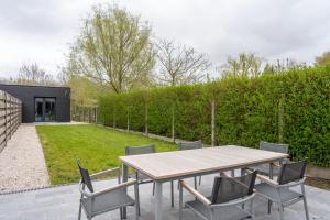 eine Terrasse mit einem Holztisch und Stühlen in der Unterkunft Modern & Spacious House in Kortrijk