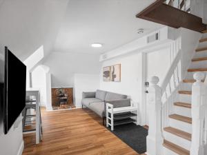 a living room with a couch and a staircase at Shadyside, Pittsburgh, Modern and Unique 1 Bedroom Unit6 with Free Parking in Pittsburgh