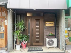 a front door of a house with a heater and plants at 瓦町駅.home201 in Takamatsu