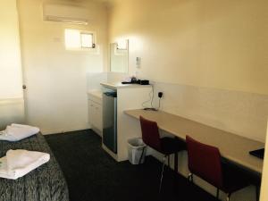 a room with two beds and a table and chairs at Park Avenue Hotel Motel in Rockhampton
