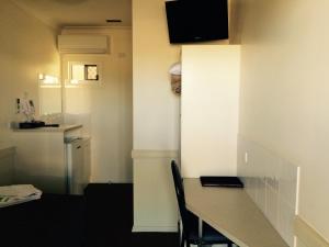 a room with a table and a kitchen with a refrigerator at Park Avenue Hotel Motel in Rockhampton