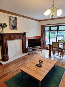 ein Wohnzimmer mit einem Kamin und einem Holztisch in der Unterkunft Beeston BIG House in Beeston