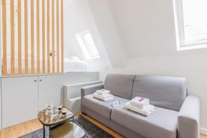 a living room with a couch and a table at Cosy Studio Etoile Friedland - MOBILITY LEASE in Paris