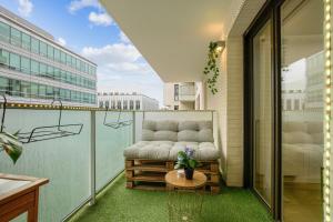 a couch sitting on a balcony with a table at Chic apart with parking near Paris in Rueil-Malmaison