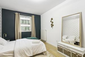 1 dormitorio con espejo y 1 cama en Chic apart with parking near Paris, en Rueil-Malmaison