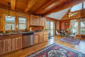 uma cozinha com armários de madeira e uma sala de jantar com uma mesa em Cozy Cove Cabin Pet Friendly & Creek Access em Marion