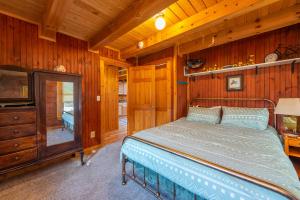 um quarto com uma cama num quarto com paredes de madeira em Cozy Cove Cabin Pet Friendly & Creek Access em Marion