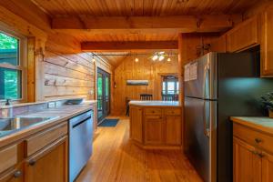 una cocina con nevera de acero inoxidable y armarios de madera en Summit Sunsets Pets & Year-Round Mountain Views!, en Marion