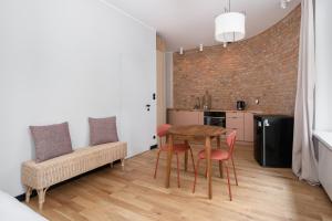 a kitchen and dining room with a table and chairs at Stary Browar Cosy Studio in Poznań
