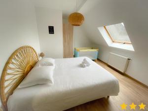 a bedroom with a large white bed and a window at Le Clos Des Oyats a Bleriot-Plage in Blériot-Plage