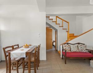 uma sala de jantar com uma mesa e cadeiras e uma escadaria em Maria's Residence em Riglia
