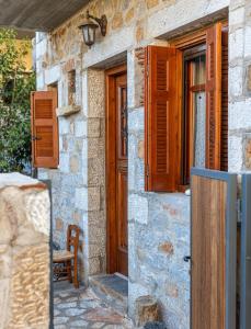 uma casa de pedra com uma porta de madeira e janelas em Maria's Residence em Riglia
