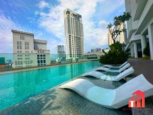 a swimming pool with lounge chairs next to a building at Heaven Cottage KLCC Suite in Kuala Lumpur
