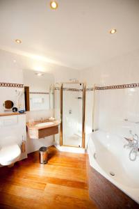 ein Bad mit einer Badewanne, einer Dusche und einem Waschbecken in der Unterkunft Chateau De Strainchamps in Fauvillers