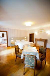 une chambre d'hôtel avec un lit, une table et des chaises dans l'établissement Chateau De Strainchamps, à Fauvillers