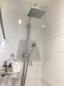 um chuveiro numa casa de banho com uma porta de vidro em Cleddon em Bournemouth