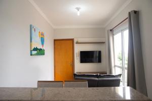 a living room with a couch and a television at Geovane Acomodação in Boituva