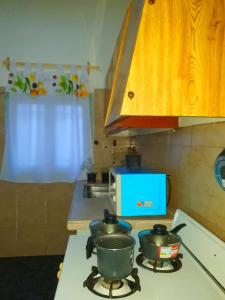 uma cozinha com duas panelas e frigideiras no fogão em BACANO hostel em Las Heras
