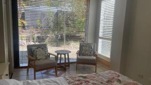 um quarto com 2 cadeiras, uma mesa e uma janela em BNE24M1 em Slacks Creek