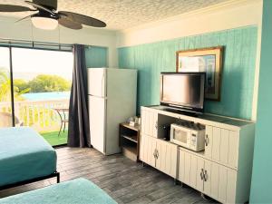 a room with a refrigerator and a tv in it at Conch Key Fishing Lodge & Marina in Conch Key