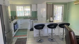 una cocina con 2 taburetes de barra en BNE24M1, en Slacks Creek