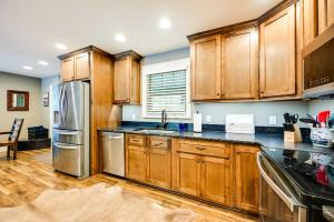 a kitchen with wooden cabinets and a stainless steel refrigerator at Nolin Lake Home with Hot Tub 15 Mi to Mammoth Cave! in Cub Run