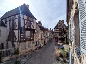 Un callejón en un casco antiguo con edificios medievales. en QUELQUES JOURS À NOYERS SUR SEREIN, en Noyers-sur-Serein