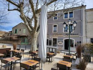 a group of tables and chairs in front of a building at L' Oustaloun in Maussane-les-Alpilles
