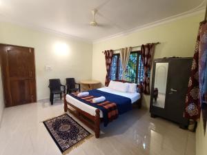 a bedroom with a bed and a table and chairs at Pappa's Guest House in Arambol