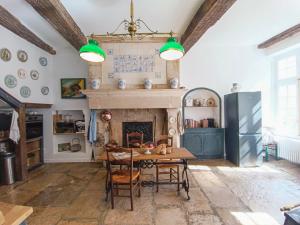 Un comedor con mesa y chimenea. en QUELQUES JOURS À NOYERS SUR SEREIN, en Noyers-sur-Serein