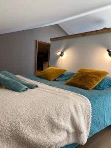 two beds with pillows on them in a bedroom at Jolie villa face aux dunes et mer in Brétignolles-sur-Mer