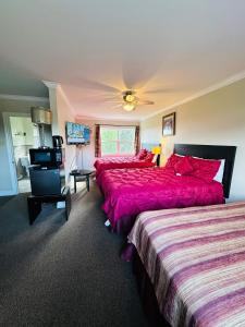 a hotel room with two beds and a flat screen tv at Scenic Motel Moncton in Moncton