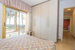 um quarto com uma cama e uma grande janela em Pins i Mar Litoral BJOS- ONLY FAMILIES em Cambrils