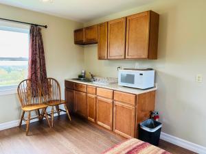 a kitchen with wooden cabinets and a microwave at Scenic Motel Moncton in Moncton